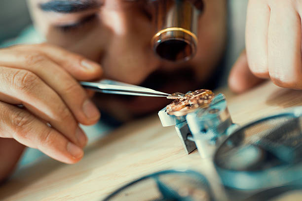 Close up portrait of a watchmaker at work.He is wearing specialist magnifying glass.