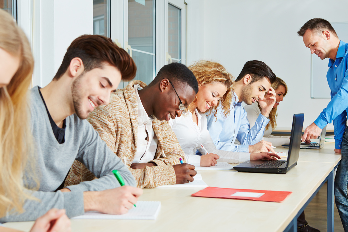 Schüler arbeiten mit Lehrer gemeinsam in einem Workshop